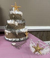 a diaper cake decorated with starfish and a tiara