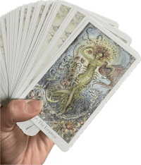 a hand holding a deck of tarot cards