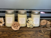 three jars of soy candles on a wooden table