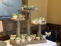 a wooden cake stand with cupcakes on it
